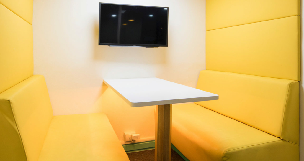 pequena sala para reuniões amarela com mesa branca